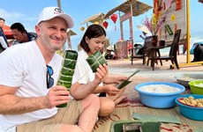 Des étrangers enthousiastes de profiter de l’ambiance festive du Têt traditionnel au Vietnam