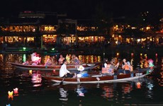 Les touristes prennent du plaisir à lâcher des lanternes sur la rivière Hoài