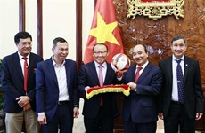 Le président Nguyên Xuân Phuc félicite les entraîneurs Park Hang-seo et Mai Duc Chung