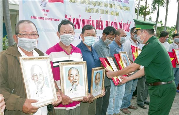 Remise des drapeaux nationaux et des portraits de l'Oncle Ho aux pecheurs des zones cotieres hinh anh 1