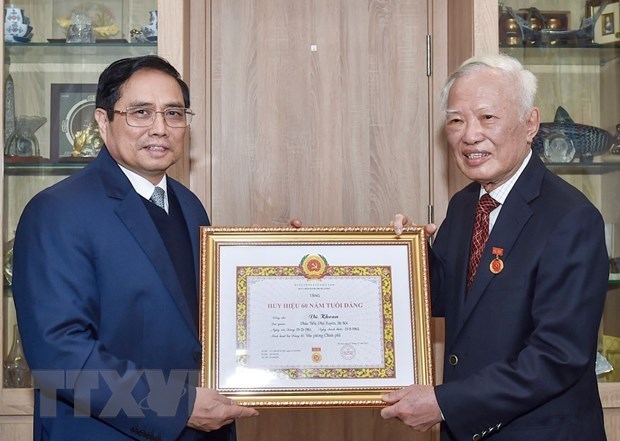 Remise de l’Insigne des «60 ans de membre du Parti » a l'ancien vice-PM Vu Khoan hinh anh 1